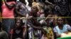 FILE - Women wait for their rations to be handed out at a food distribution site in Kasala, Kasai region, Democratic Republic of Congo, Oct. 25, 2017. 
