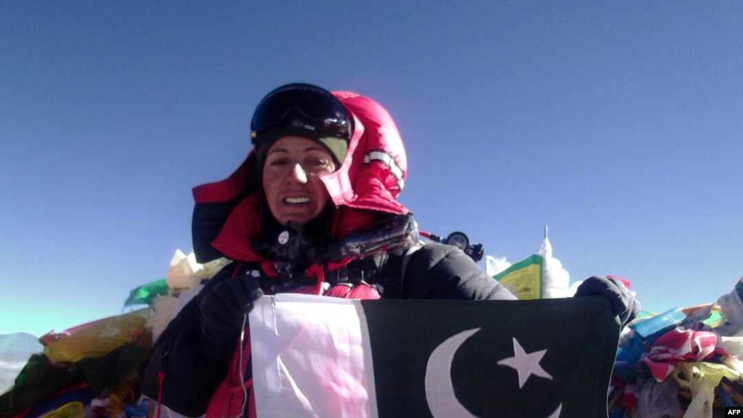 Samina Baig, perempuan pendaki gunung asal Pakistan, memegang bendera nasionalnya di puncak Gunung Everest, Nepal, 19 Mei 2013. (AFP/PAKISTAN Youth OUTREACH)
