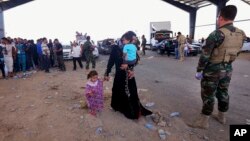 A Kurdish policeman stands guard while refugees fleeing Mosul head to the self-ruled northern Kurdish region in Irbil, Iraq, June 10, 2014. 