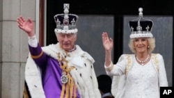 El rey Carlos III y la reina Camila saludan a la multitud desde el balcón del Palacio de Buckingham, después de la ceremonia de coronación en Londres, el sábado 6 de mayo de 2023. (Foto AP/Frank Augstein)