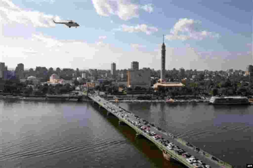 An Egyptian army helicopter flies over Cairo as it monitors protesters, not seen, gathered in Tahrir (Liberation) Square, in Cairo, Egypt, Monday, Jan. 31, 2011. A coalition of opposition groups called for a million people to take to Cairo's streets Tuesd