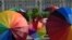 People hold rainbow umbrellas to celebrate International Day Against Homophobia, Biphobia and Transphobia in the front of the Romanian Parliament building in Bucharest, May 17, 2016. 