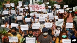 Protesters hold slogans condemning the military government as they mark the Thingyan festival on April 13, 2021 in Yangon, Myanmar.