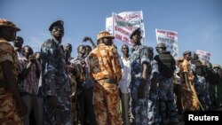 Policemen stand guard as protesters representing regions along the border with Sudan gather outside of the Parliament building in Juba, South Sudan, against a recently signed agreement between Sudan and South Sudan, October 15, 2012. 