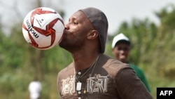 La star ivoirienne de football Didier Drogba joue au ballon lors de l’inauguration du terrain de l'école primaire Didier Drogba, à Pokou-Kouamekro, près de Gagnoa, en Côte d'Ivoire, le 17 janvier 2018.