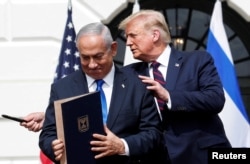 Perdana Menteri Israel Benjamin Netanyahu berdiri bersama Presiden AS Donald Trump setelah menandatangani Perjanjian Abraham yang menormalisasi hubungan Israel dengan beberapa negara Timur Tengah, di Washington, 15 September 2020. (Foto: Tom Brenner/Reuters)