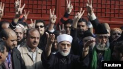 Tahir-ul Qadri, center, leader of Mihaj-ul-Quran movement, speaks before a protest march from Lahore to Islamabad, January 13, 2013.