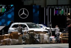 Cars and workers are pictured at the Palexpo exhibition center as the 90th edition of the International Motor Show is canceled to curb the spread of the coronavirus, in Geneva, Switzerland, Feb. 28, 2020.