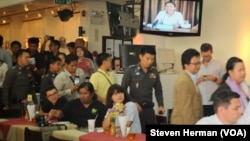 Police officers inside the Foreign Correspondents Club to deliver letters to human rights panelists.