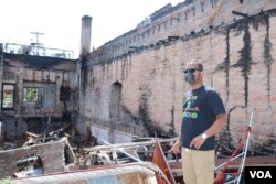 Ruhel Islam walks around the remains of the restaurant. (K. Khan/VOA)