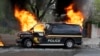 A police vehicle burns during unrest following the funeral of Freddie Gray in Baltimore, April 27, 2015.