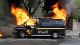 A police vehicle burns during unrest following the funeral of Freddie Gray in Baltimore, April 27, 2015.