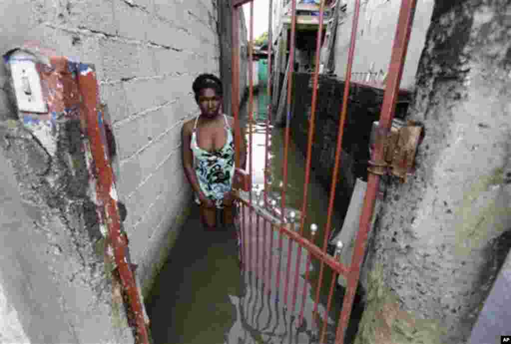 Maria Carlota, de 37 anos, é um espelho de tristeza, neste foto tirada junto à sua casa inundada, no bairro de Vila Itaim, em São Paulo.