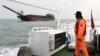 A Taiwanese coast guard looks at a sand-dredging ship with Chinese flag in the waters off the Taiwan-controlled Matsu islands, January 28, 2021. (REUTERS/Ann Wang)