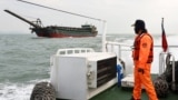 A Taiwanese coast guard looks at a sand-dredging ship with Chinese flag in the waters off the Taiwan-controlled Matsu islands, January 28, 2021. (REUTERS/Ann Wang)