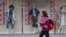 A shopper walks past a clothing shop display on a shopping street in Tokyo Monday, Feb. 15, 2016.