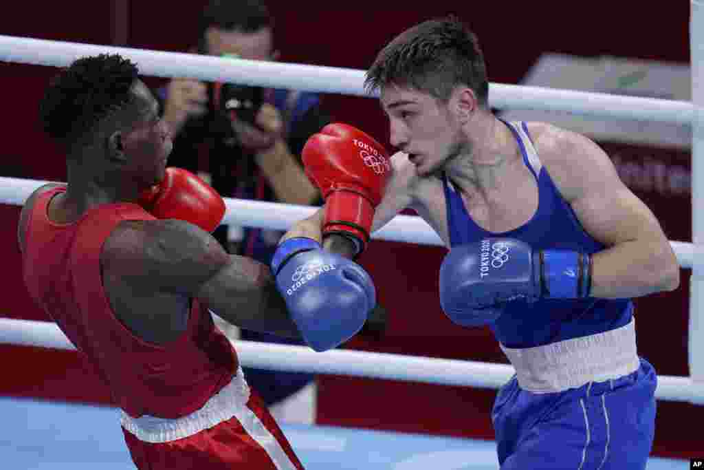 Uganda&#39;s Shadiri Bwogi, left, exchanges punches with Georgia&#39;s Eskerhan Madiev during their men&#39;s welterweight 69-kg boxing match at the 2020 Summer Olympics, Tuesday, July 27, 2021, in Tokyo, Japan. (AP Photo/Frank Franklin II)