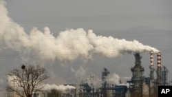 FILE - Smoke and steam rise from a coal processing plant in Hejin in central China's Shanxi Province, Nov. 28, 2019.