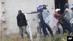 FILE: Armed Zimbabwean police clash with rioters in Harare, Monday, July 4, 2016. (AP Photo/Tsvangirayi Mukwazhi)