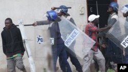 FILE: Armed Zimbabwean police clash with rioters in Harare, Monday, July 4, 2016. (AP Photo/Tsvangirayi Mukwazhi)