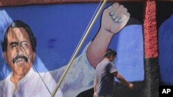 Un hombre pasa junto a un mural con la imagen del presidente de Nicaragua, Daniel Ortega, durante las elecciones generales en Managua, Nicaragua, el domingo 7 de noviembre de 2021.