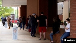 FILE PHOTO: People who lost their jobs wait in line to file for unemployment following an outbreak of the coronavirus disease (COVID-19), at an Arkansas Workforce Center in Fort Smith, Arkansas, U.S. April 6, 2020.
