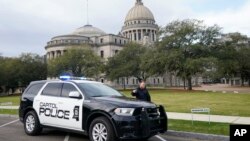 A Capitol Police officer warns off passersby as they respond to a bomb threat at the Mississippi State Capitol in Jackson, Miss., Jan. 3, 2024. The building was emptied and the grounds cleared of vehicles as officers investigated.