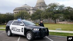 Seorang petugas Polisi Capitol memperingatkan orang yang lewat sebagai tanggapan atas ancaman bom di Mississippi State Capitol di Jackson, 3 Januari 2024. Gedung dikosongkan, halaman dibersihkan dari kendaraan. (Foto: AP/Rogelio V. Solis)