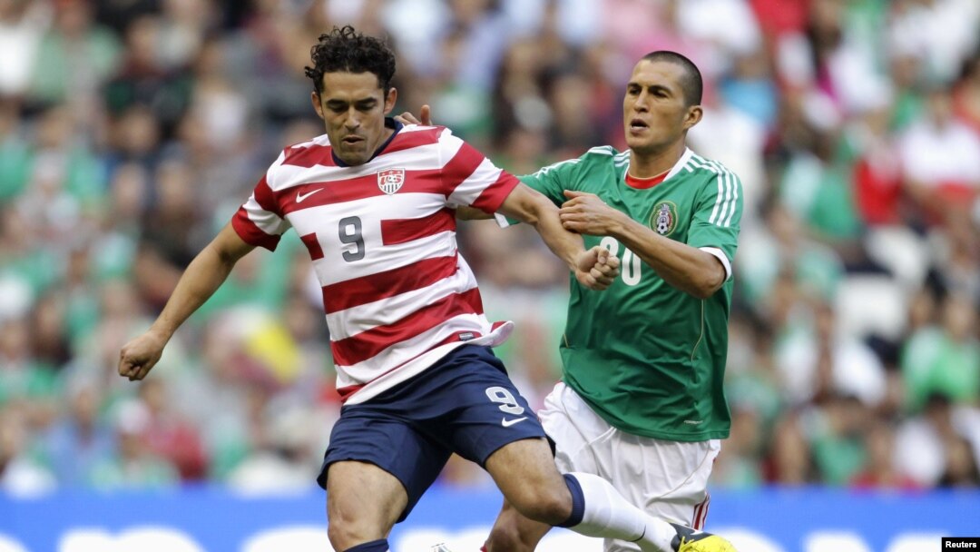Hérculez Gómez (kiri) mempertahankan bola dari pemain Meksiko Jorge Torres Nilo dalam partai CONCACAF antar AS dan Meksiko (15/8).