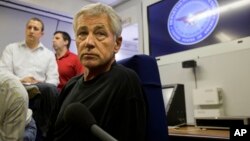 U.S. Secretary of Defense Chuck Hagel turns to listen to a question from the traveling press aboard a U.S. military aircraft en route to Seoul, South Korea, Sept. 28, 2013.