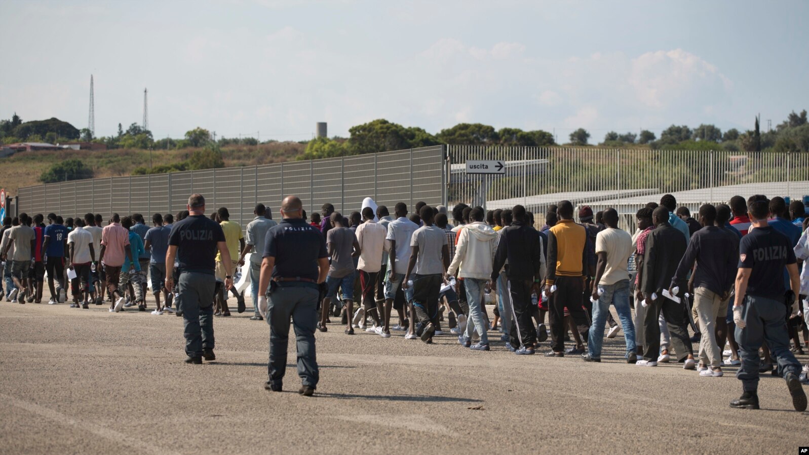 FILE - Italian border police escort sub-Saharan men on their way to a relocation center, after arriving in the Golfo Azzurro rescue vessel at the port of Augusta, in Sicily, Italy, June 23, 2017. 
