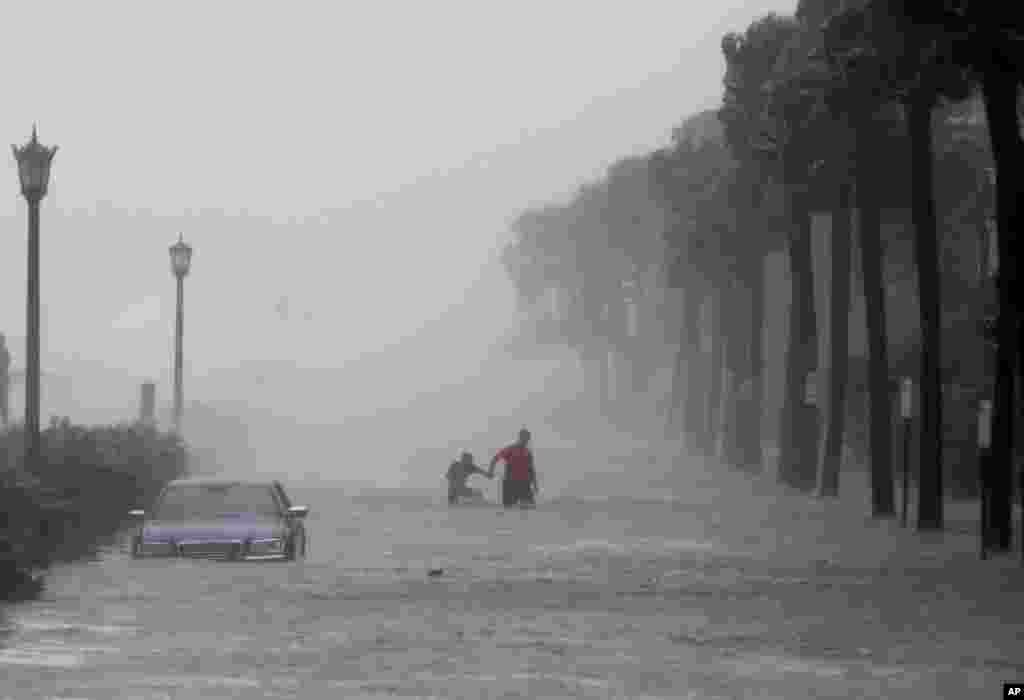 Pedestrians walk through a flooded street as Tropical Storm Irma hits Charleston, South Carolina.