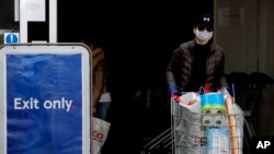 Shoppers wear face masks to protect against the coronavirus outbreak as they do their weekend shopping at a supermarket in London, April 17, 2020. 