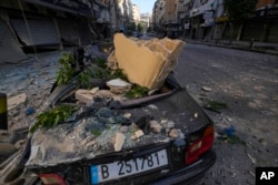 Remains of a wrecked car sit next to the site of an Israeli airstrike in Dahiyeh, Beirut, Lebanon, Oct. 3, 2024.