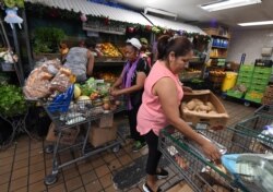 FILE - People on low incomes and retirees choose food at the World Harvest Food Bank in Los Angeles, July 24, 2019.