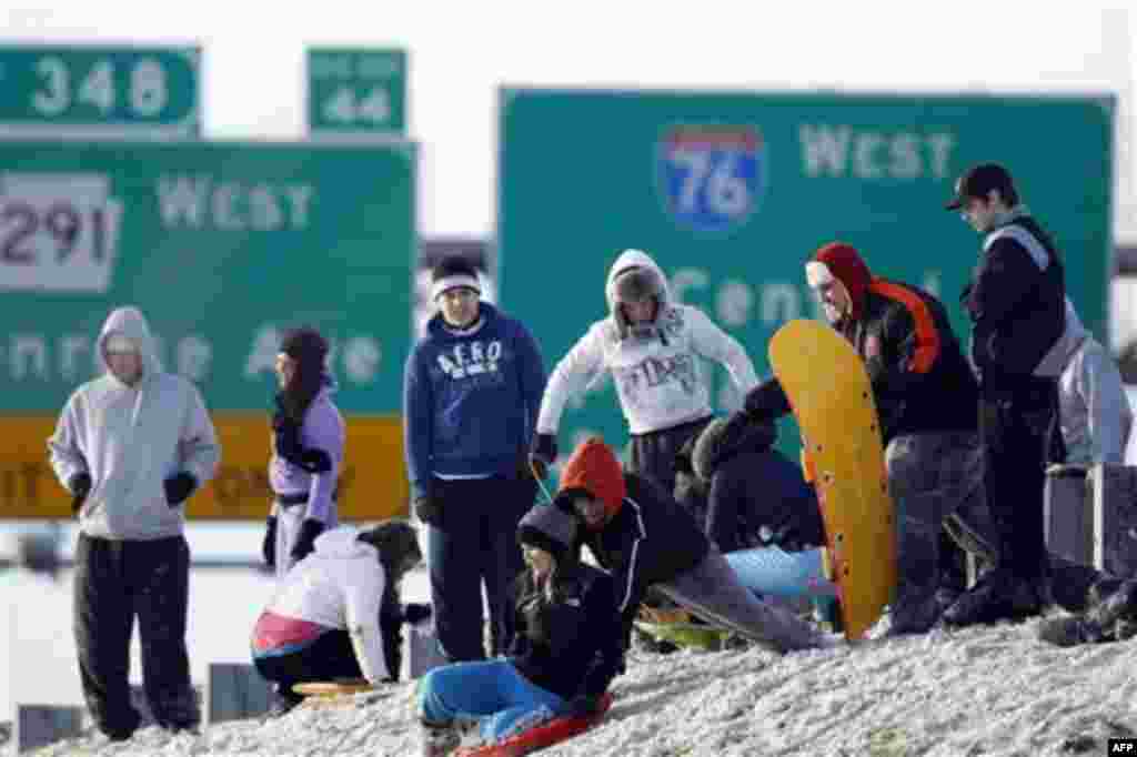 People gather to slides down a snow covered embankment next to Interstate 95 in Philadelphia, Monday, Dec. 27, 2010. (AP Photo/Matt Rourke)