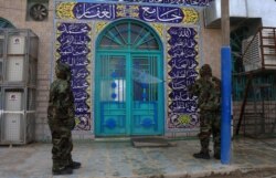 FILE - Soldiers disinfect the exterior of a mosque as a preventive measure against the spread of the coronavirus COVID-19, in the Shi'ite shrine city of Karbala, south of Iraq's capital Baghdad, March 7, 2020.