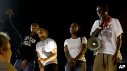 A small group of people protest outside the police station, Sept. 26, 2014, in Ferguson, Missouri.