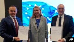 FILE - Maxim Timchenko, CEO DTEK, from left, Kadri Simson, European commissioner for energy, Morten Dyrholm, of company Vestas, pose for a photo at the Ukraine Pavilion at the COP28 U.N. Climate Summit, December 4, 2023, in Dubai, UAE.