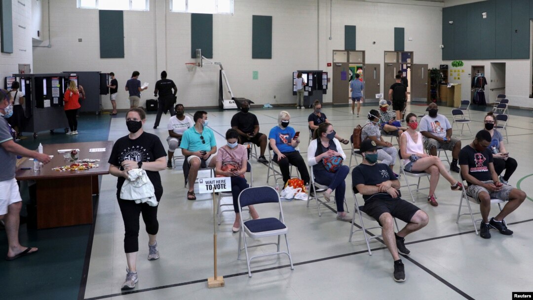 Para pemilih menunggu di sebuah TPS untuk memberikan suara mereka setelah pemilihan pendahuluan Partai Demokrat dan Republik ditunda karena pandemi Covid-19 di Atlanta, Georgia, AS, 9 Juni 2020. (REUTERS / Dustin Chambers)