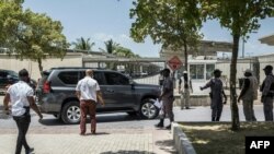 Security officers checks the surroundings of a convoy of dark-colored vehicles as it makes its way to the U.S. embassy in the Tabarre neighborhood of Port-au-Prince, Haiti, July 11, 2021.