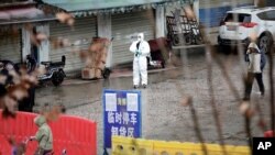 Un trabajador con traje protector es visto en enero del 2020 en el clausurado mercado de mariscos en Wuhan, China, del cual se cree surgió el coronavirus.