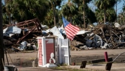 Sebuah bendera Amerika berkibar di tengah kehancuran kawasan permukiman akibat Badai Helene, di kota Jena, Florida, Minggu, 29 September 2024.