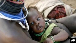 A Turkana woman carries her child at a peace meeting in the Lobei Kraal village of Turkana district in North-western Kenya (file photo)