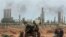 FILE - Anti-government rebels take their position in front the refinery oil complex, in eastern Libya, March 10, 2011.