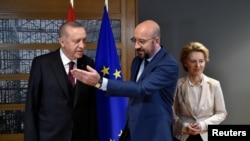 EU Council President Charles Michel, center, and European Commission President Ursula von der Leyen, right, welcome Turkish President Tayyip Erdogan before their meeting at the EU headquarters in Brussels, Belgium, March 9, 2020. 