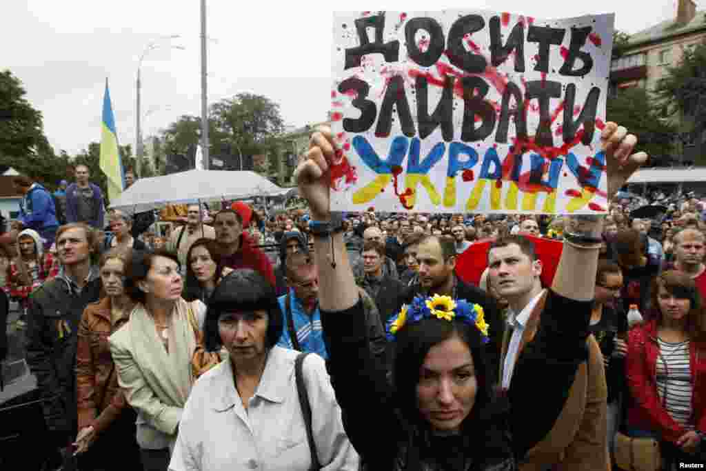 Public activists and relatives of soldiers hold a banner which says stop giving away the Ukraine, in Kyiv, Aug. 28, 2014.