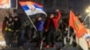 Students and opposition supporters hold flags during a protest over the fatal November 2024 Novi Sad railway station roof collapse, in Nis, Serbia, March 1, 2025.