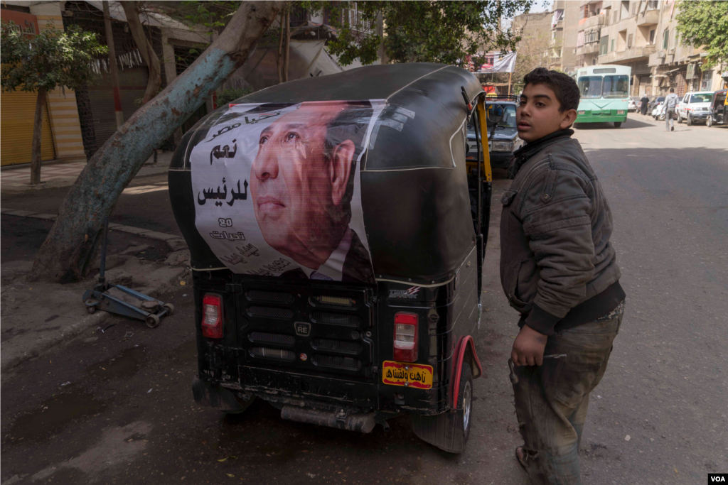 A young driver in Cairo shows off an al-Sissi campaign banner calling voters to say &#39;Yes to the President.&#39; Many Egyptians see al-Sissi as the only choice in this election, March 26, 2018. (H. Elrasam for VOA)