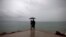 FILE - A couple looks out to sea as hurricane-related rainfall increases in Puerto Vallarta, Mexico. 